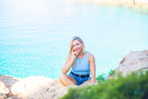 Lydia sitting by the sea in Ibiza