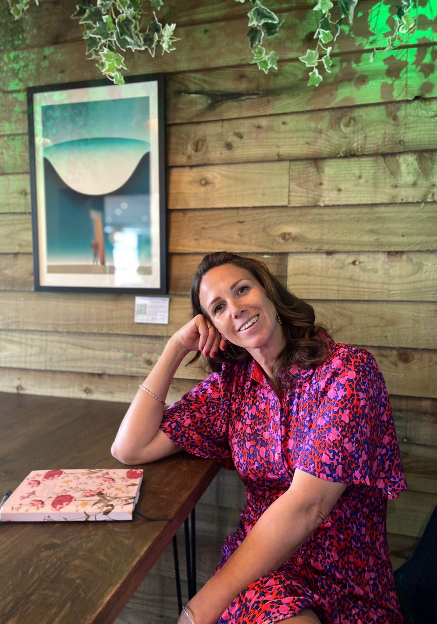 Happy woman sat by a desk