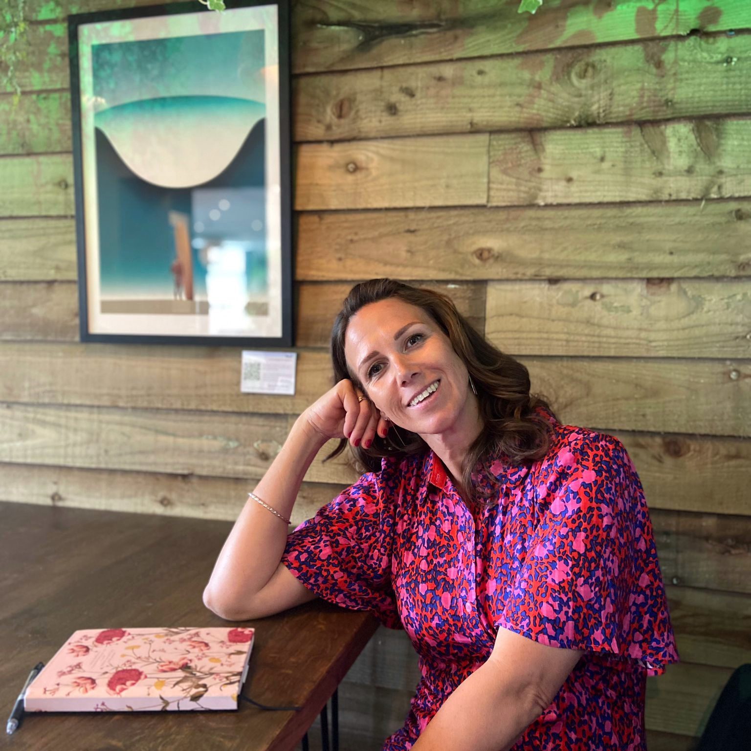 Happy woman sat by a desk